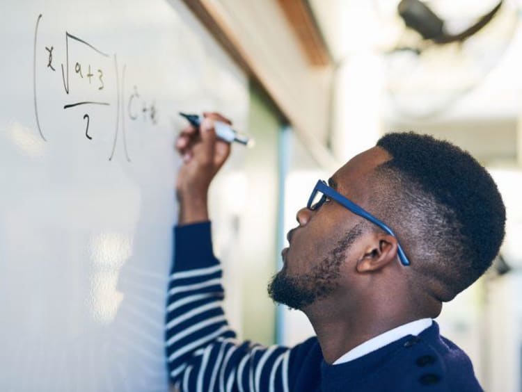 Man writing math on the board