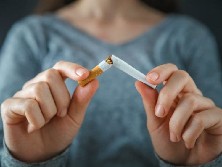 a girl breaking a cigarette