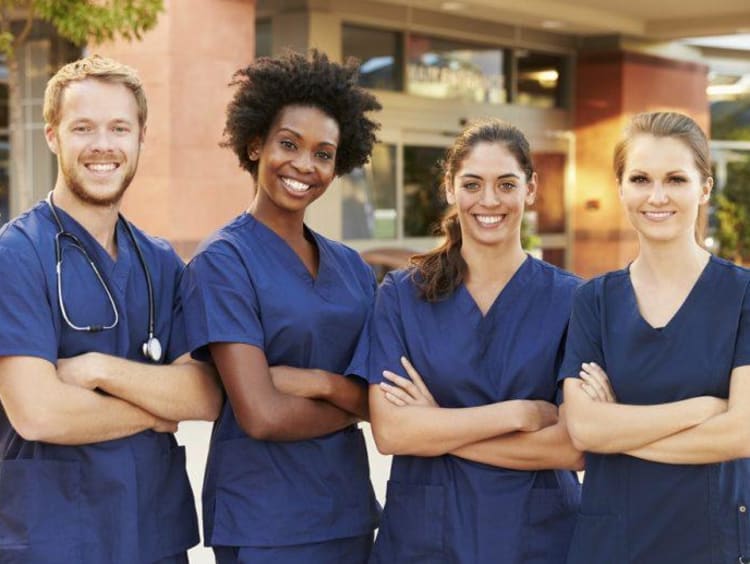 Four nurses standing with arms crossed