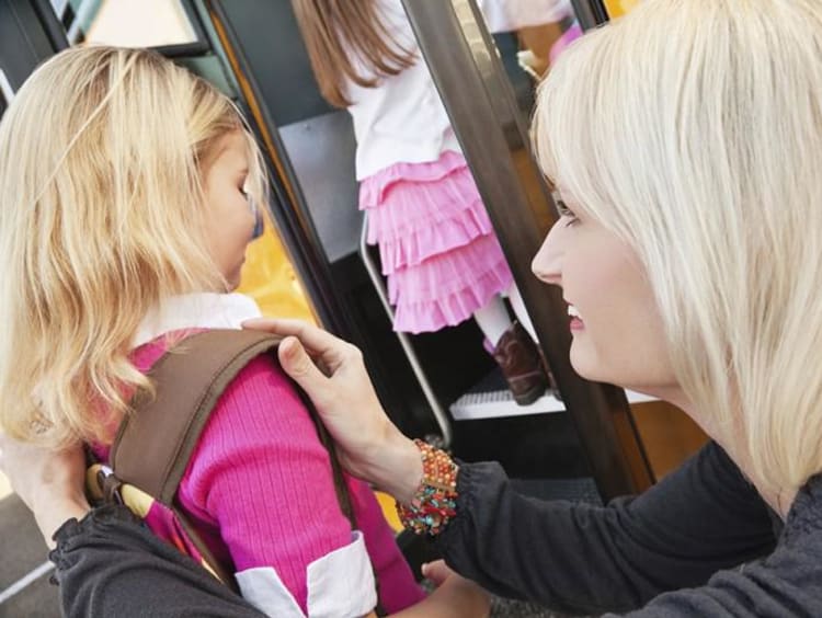 Parent helping girl with backpack