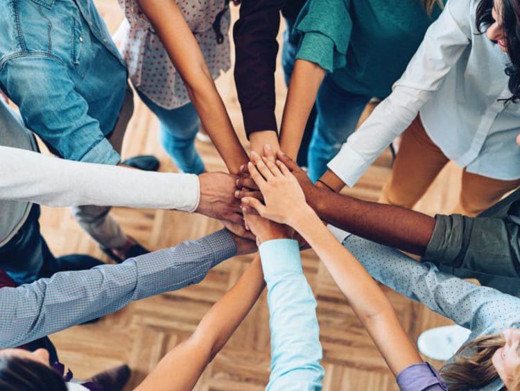 Team members combined hands to promote solidarity