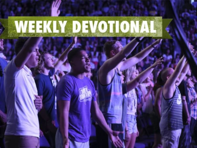 A group of students worshiping at Chapel under the Weekly Devotional banner