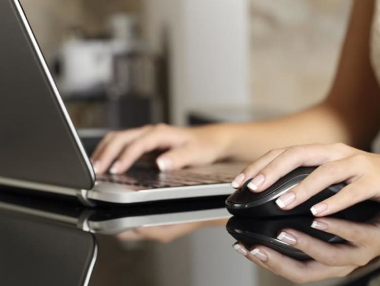 hands typing on computer and hand on mouse