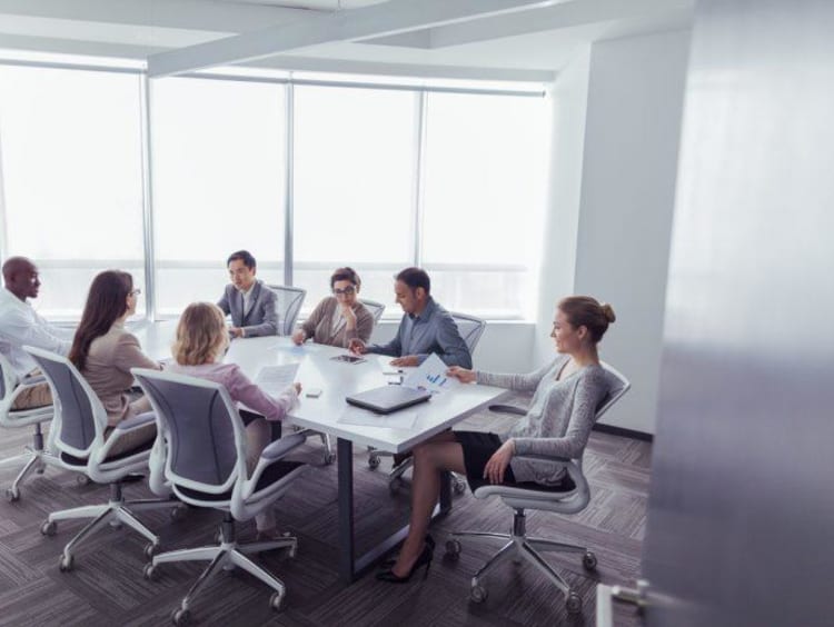 Conference room with professionals reviewing research proposals