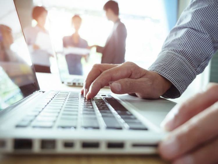 man typing on laptop