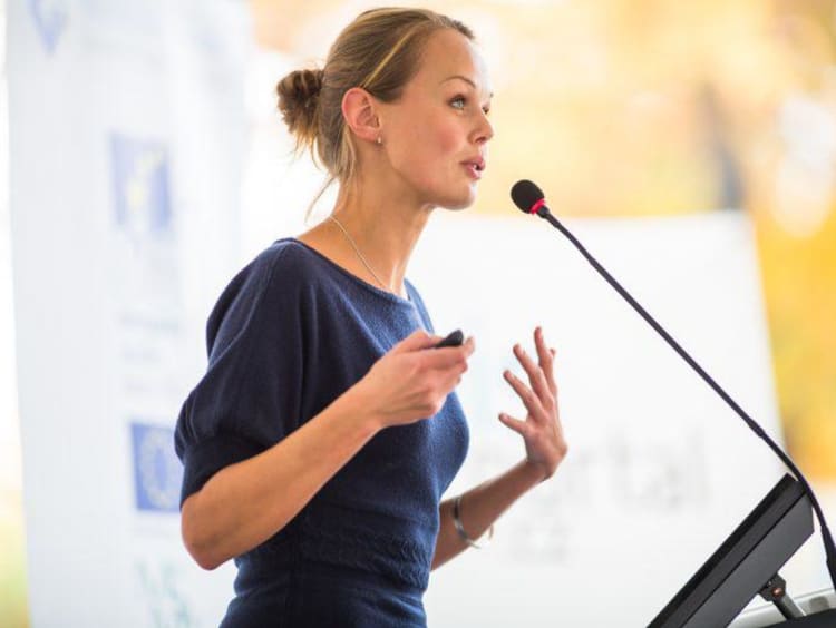 Adult woman speaking into microphone