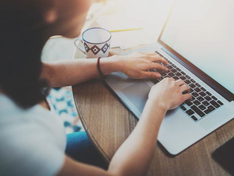 girl writing on a laptop