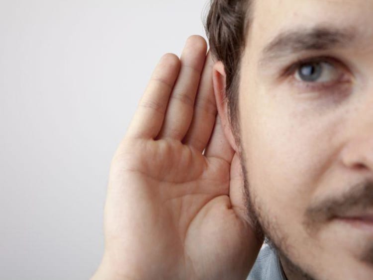 Man holding his hand to his ear to listen