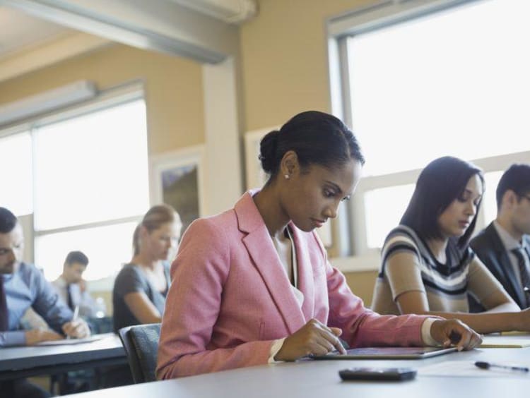 Woman using digital tablet in training class