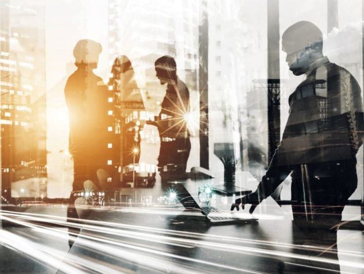 group of people walking behind glass