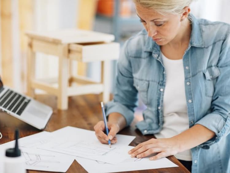 Middle-aged woman works on a table sketch design