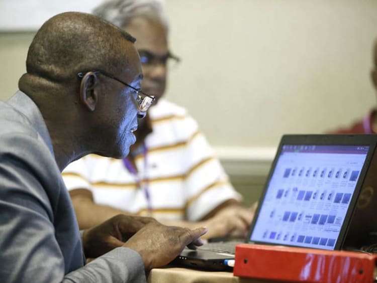 Adult discuss classes over a laptop