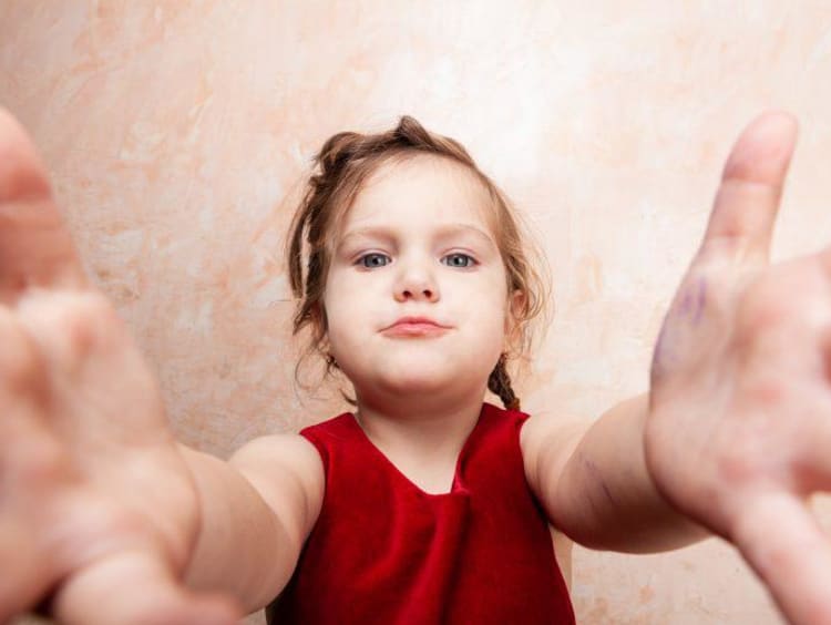 Young child reaching her arms out