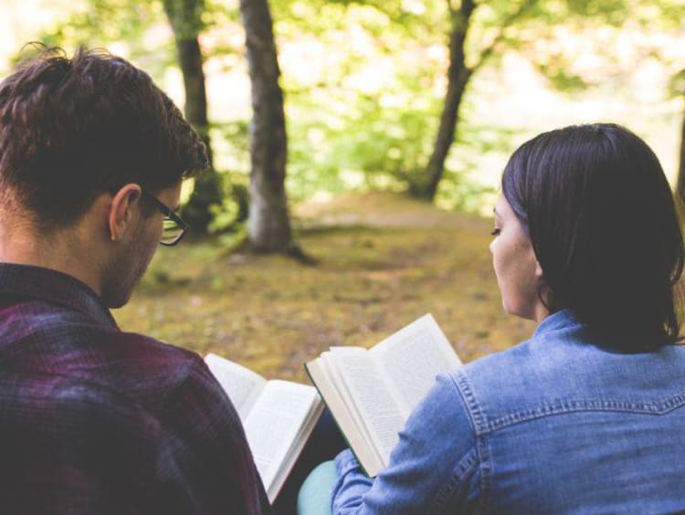 Two young adults reading scripture together.