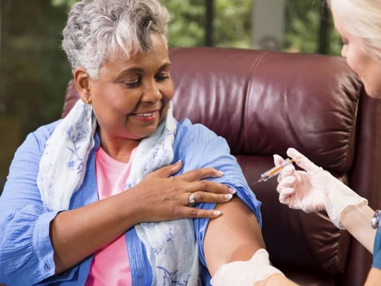 nurse vaccinating an older woman