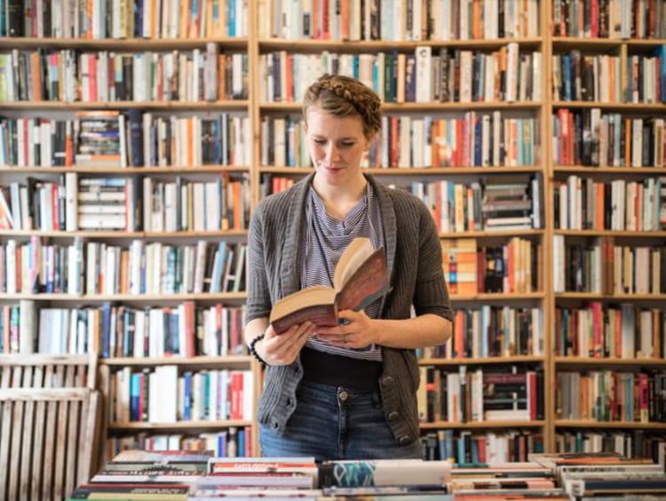 Woman reading books in a library