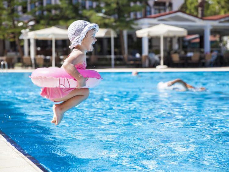 little girl jumping into a pool