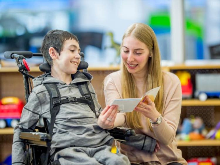 special education teacher helping a student read