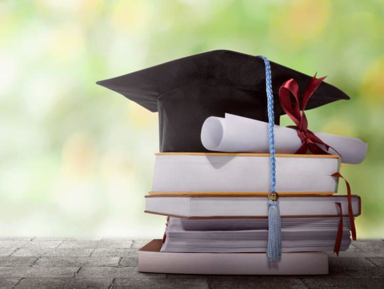 A grad cap on top of a stack of books