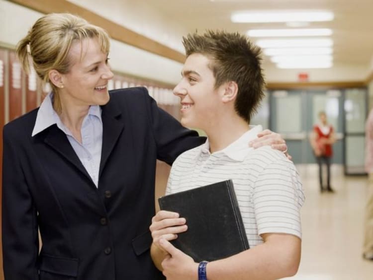 teacher with arm around student