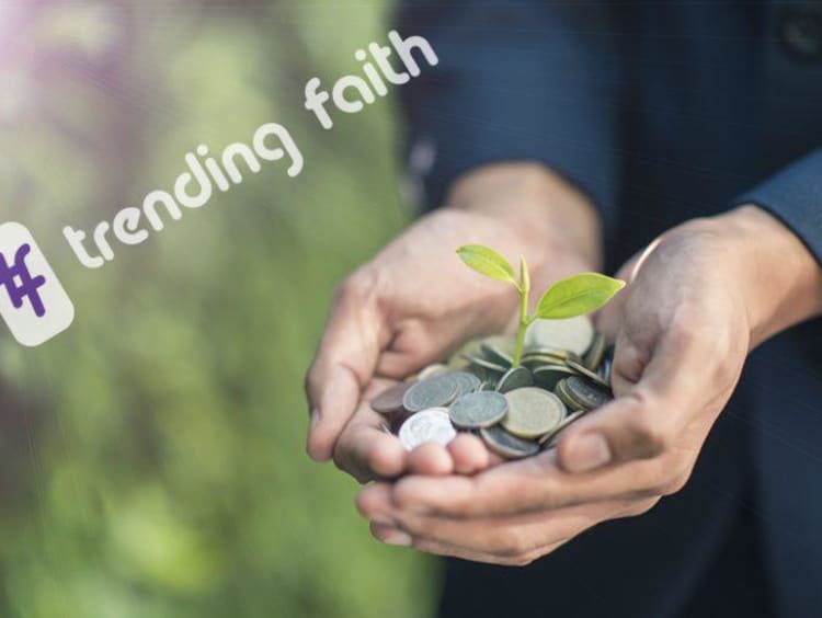 Hands hold coins with a plant sprouting out of them