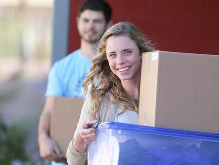 Woman and a man carrying boxes