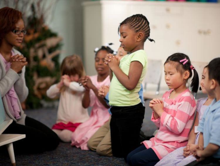 children praying in a class