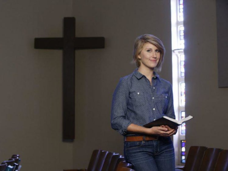 woman standing in front of cross