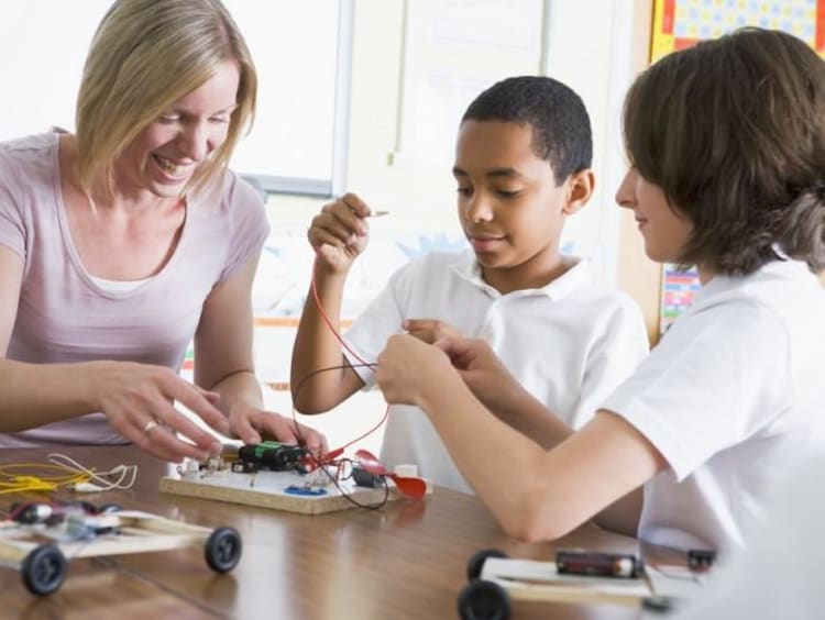 teacher helping students with project