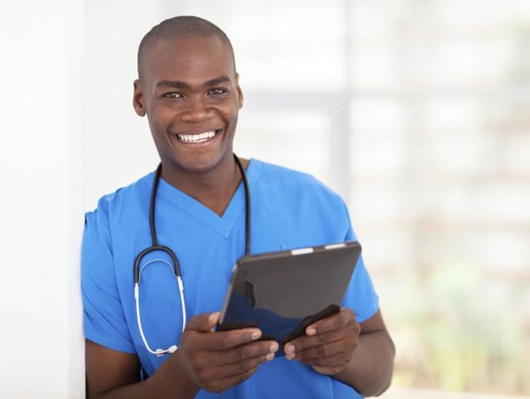 male nurse holding clipboard and smiling