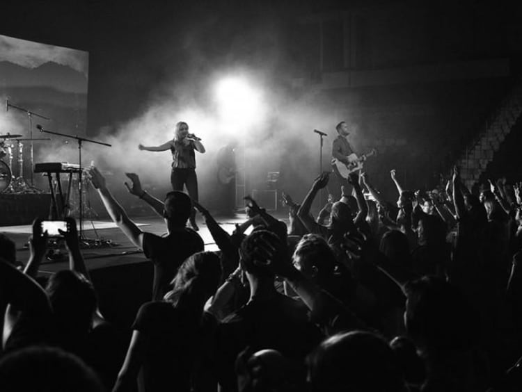 people worshiping in black and white