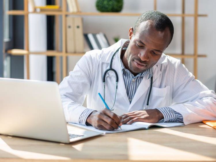 Concentrated brunette writing notes into copybook