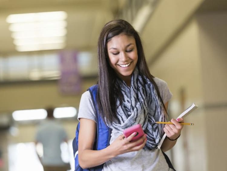 a girl laughing while texting