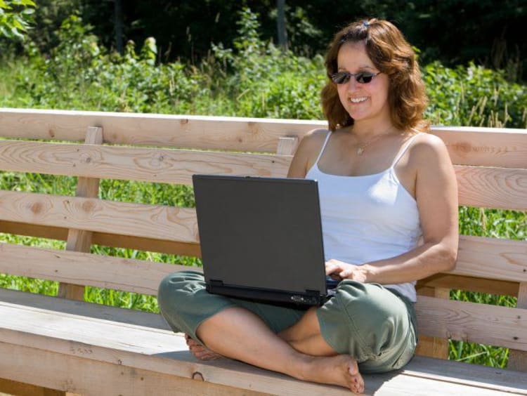 Doctoral student uses laptop in park