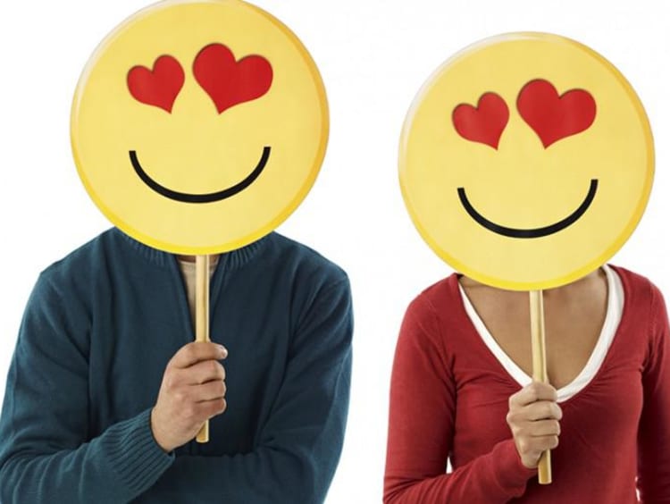 two people holding up heart-eye emojis