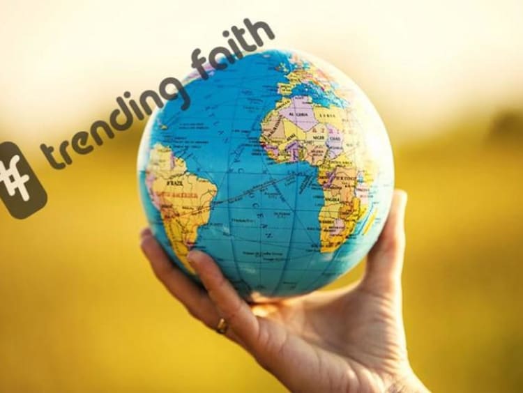 A hand holding a globe under the Trending Faith logo