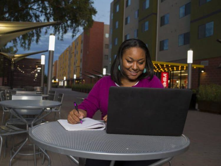 a woman taking classes on her laptop during the evening