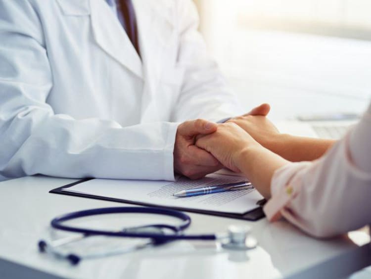 Doctor holding patients hands