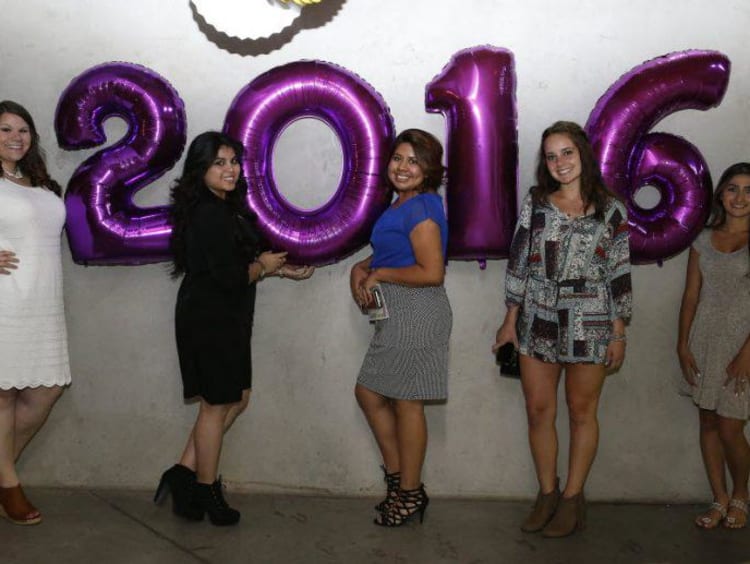 people standing next to 2016 balloons