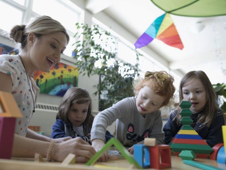 Teacher looks excited doing crafts with young kids