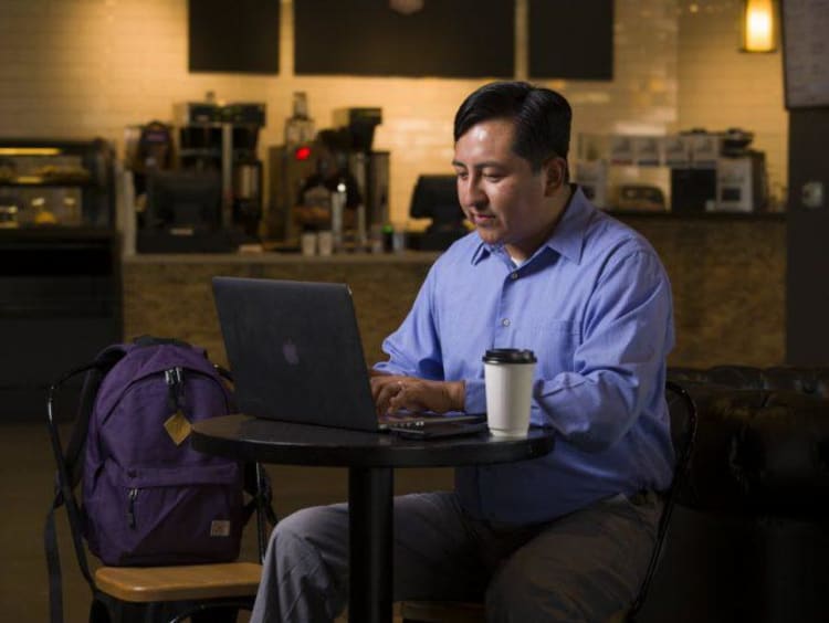 man working on a computer in a coffee shop