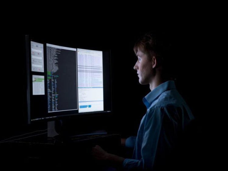 Computer programmer working in the dark