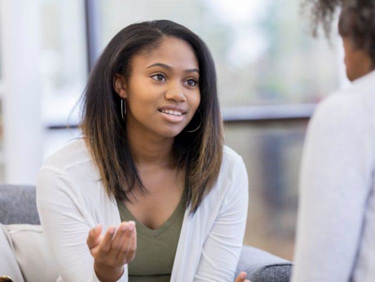 Young African-American female has hope in eyes talking with a psychologist