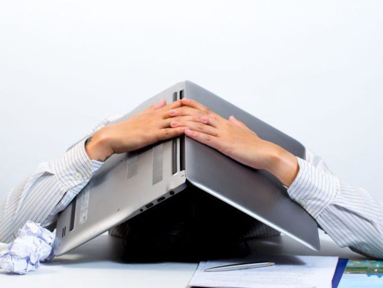 Entrepreneur handling failure poorly with a laptop over his head