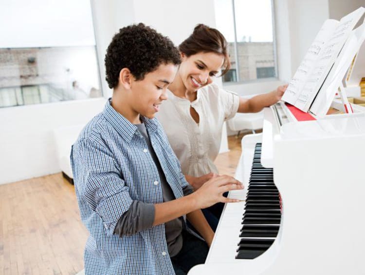 woman teaching piano to a child