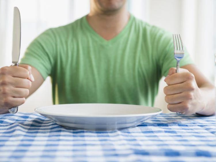 Man sitting in front of an empty plate