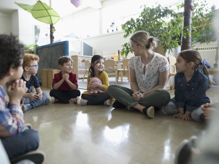 Students and a teacher gathered into a circle