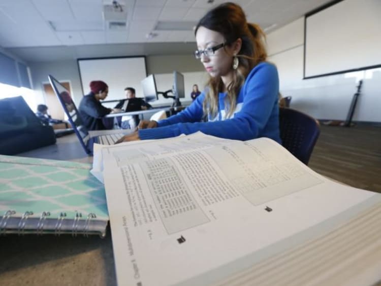 Student review textbooks in library setting