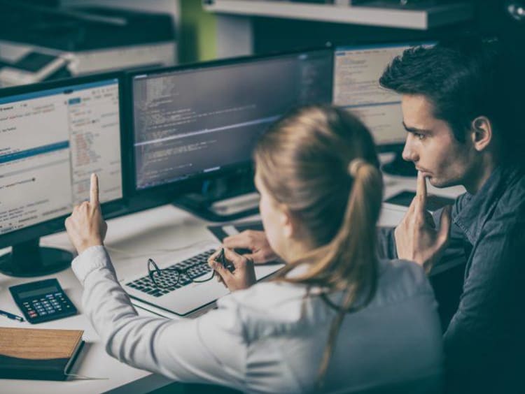 two people looking at a computer