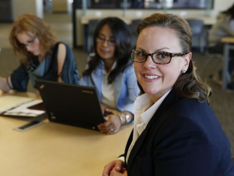 Group of women gather at table for cohort learning